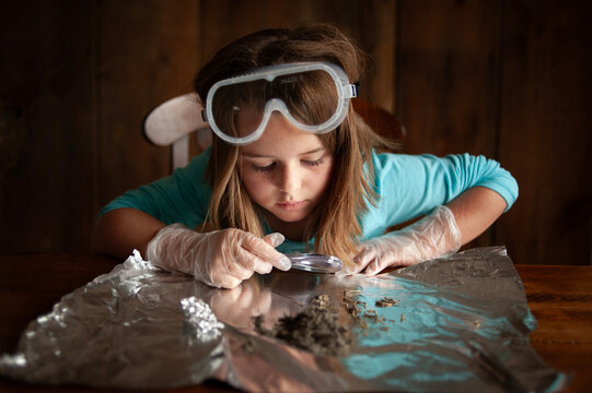 Young female wearing goggles science experiment at home