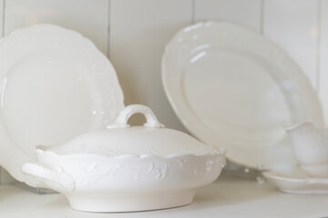 Closeup of white ceramic serving ware on shelf
