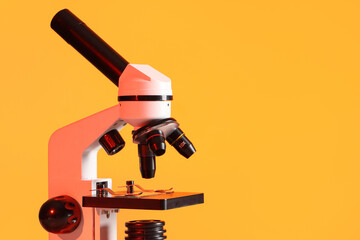 Modern microscope on orange background