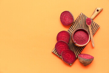 Bowl with beet powder on orange background