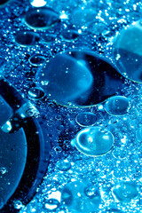 Close up of oil bubbles in water abstract circle liquid wet rain in a blue background