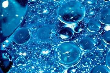 Close up of oil bubbles in water abstract circle liquid wet rain in a blue background