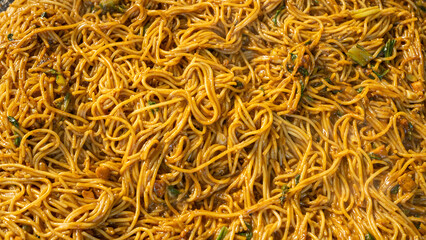 A close-up shot of stir-fried noodles with fresh vegetables in a rich sauce, cooked to perfection, presenting a delicious and appetizing dish for food lovers.