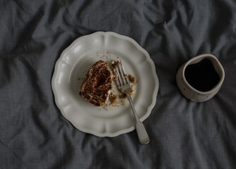A cup of coffee and a portion of tiramisu on a gray background, top view