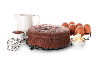 Delicious chocolate sponge cake with ingredients and whisk on white background