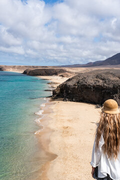 Papagallo beach view with woman standing on the shore during in Lanzarote