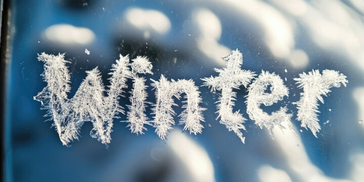 The word "Winter" is written on a frosty window with beautiful snowflakes and icy details, creating a festive and seasonal ambiance..