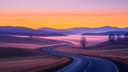 Fototapeta premium A winding road stretches through a misty landscape at sunrise, surrounded by gentle hills and soft pastel colors.