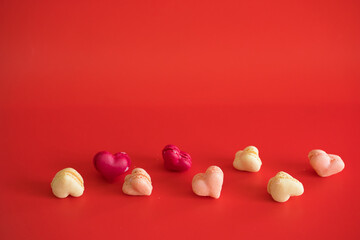 flat lay heart shape of macarons on red background