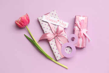 Figure 8 made of paper, tulip flower, card with text HAPPY WOMEN'S DAY and gift boxes on lilac background. Women's Day celebration.