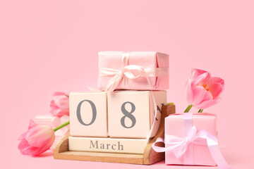Cube calendar, gift boxes and flowers for International Women's Day celebration on pink background