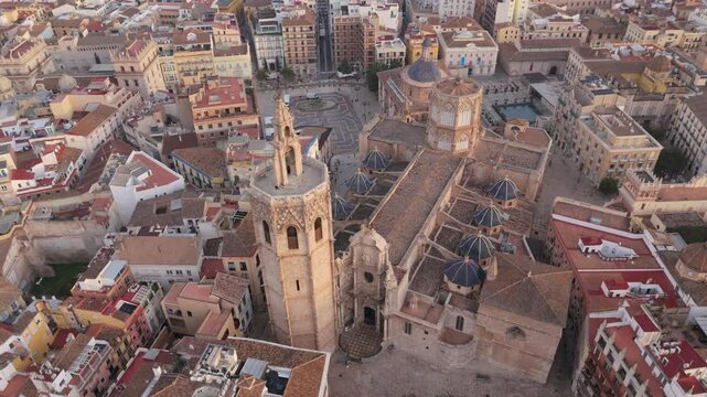 Stunning Cinematic aerial drone view of Valencias Old Town, featuring the magnificent Cathedral of Santa Maria and historic Palace of the Generalitat in the lovely Plaza de la Virgen, Valencia, Spain