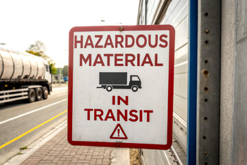 A sign warning about hazardous materials being transported, featuring a truck icon and a caution symbol.