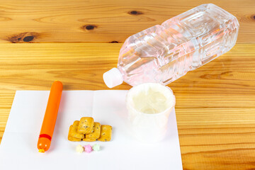 ビニール袋でカバーされた水が入った紙コップと避難所での一食の配給食料