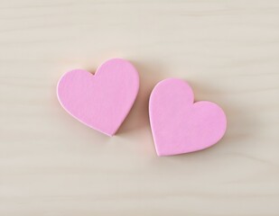 Obraz premium Two pink heart-shaped erasers on light wooden background