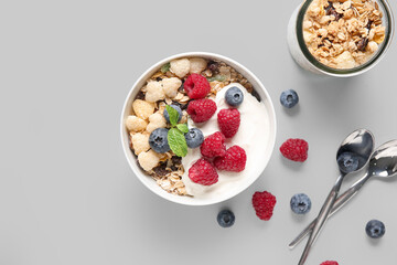 Bowl with healthy cornflakes, yogurt and berries on white background