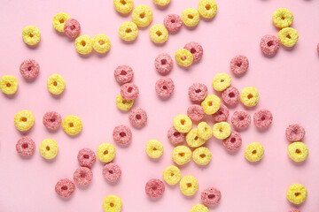 Scattered color cereal rings on pink background