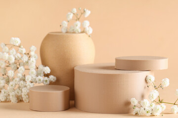 Beautiful gypsophila and plaster podiums on beige background