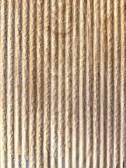 Close-up view of textured, striped surface showcasing natural wood grain in warm tones. Vertical background