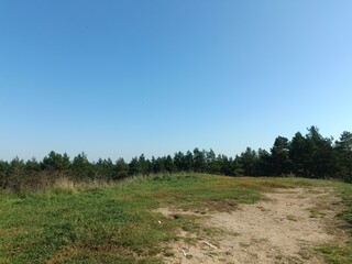 Salduve hill during sunny day. Small hill. Grass is growing on hill. Staircase leading to the top....