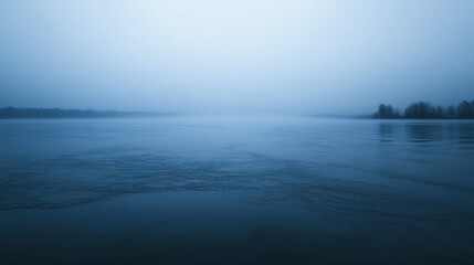 Fototapeta premium Misty river at dawn, calm water, serene landscape.