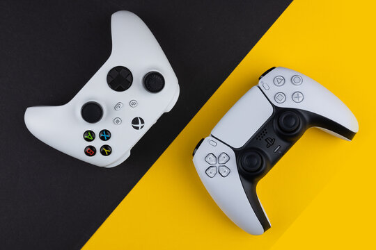Dnipro Ukraine - dec 29, 2024: Playstation 5 game dualsense and xbox one controller on black and yellow background