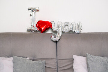 Festive Valentine's day decor, I Love You balloon on sofa.