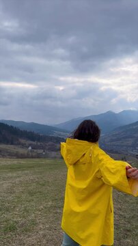 Visit to scenic mountains wearing a bright yellow jacket in tranquil landscape