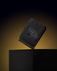 black men's wallet made of genuine leather on a gold background, object photography, object photo of a wallet, men's accessories