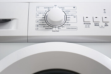 Bottom view of the control panel and drum conteiner of a modern washing machine gray color. Circle selector for choosing the washing mode.