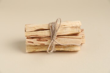 Bunch of palo santo sticks on beige background, closeup