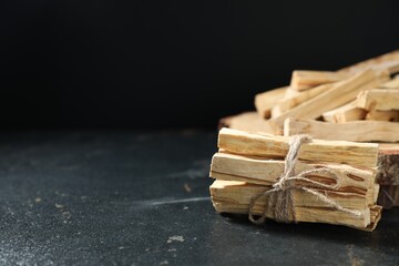 Palo santo sticks on dark table, closeup. Space for text