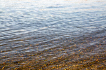 Background of river water with stones at the bottom. Texture of water and stones