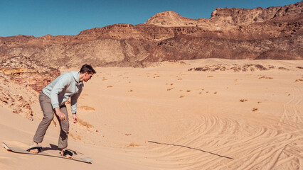 man sandboarding colored canyon in the Sinai desert in Egypt