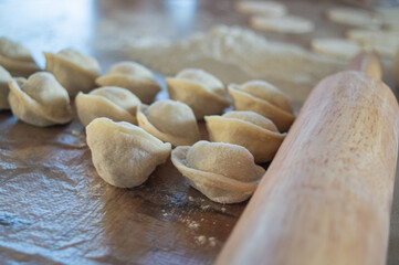authentic photo of dumpling making at home. There is a dough on the table, flour and ground beef with onion for dumplings. High quality photo