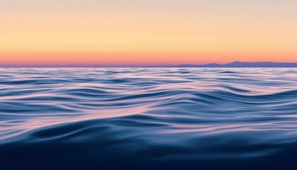 Obraz premium Serene ocean waves at sunset with distant mountains