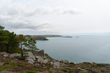 Obraz premium Sous un ciel gris épais, les falaises de la presqu'île de Crozon dominent la baie de Douarnenez, créant une vue panoramique paisible sur les plages de la région.