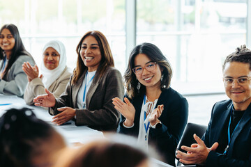 Diverse business team in a meeting exchanging feedback and applause, fostering collaboration and...