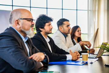 Fototapeta premium Indian Asian Corporate professionals engaged in a business interview or discussion across table