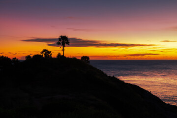 Background of young couples or solo travelers watching the natural light of the sunset at the Phuket seaside, Promthep Cape, a famous viewpoint that travelers from all over the world always visit.