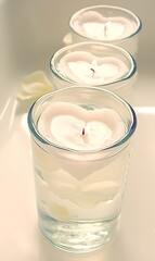 Three heart-shaped candles in glass holders.
