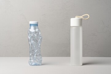 No plastic, Zero Waste, Sustainable Lifestyle. Choice Plastic Free Items alternative to disposable. Crumpled plastic bottle and glass bottle on gray background.