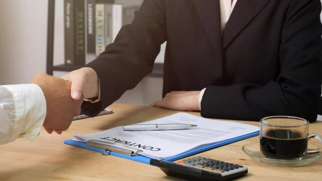 Estate agent giving house keys to client and shaking hands after signing agreement contract real estate with approved mortgage application form, concerning mortgage loan offer for and house insurance