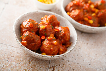 Homemade meatballs with hot sauce and corn