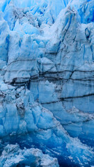 Vertical image of  Black lines visible on the edge of the blue iced of the Perito Moreno Glacier, , Los Glaciares National Park, Argentina
