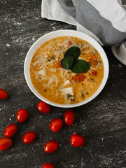 Soup in a white plate on a black background