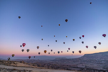 Hundreds of hot air balloons rising over the valley near Göreme in Cappadocia, Turkey at sunrise