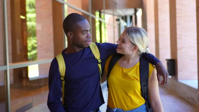 Multi-ethnic couple embracing walking along university