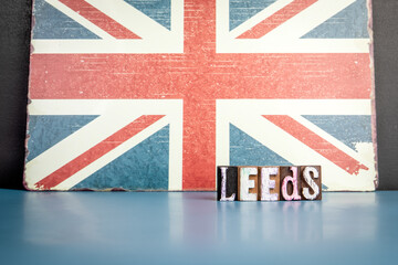 Fototapeta premium LEEDS. Urban Area in Great Britain. Flag and alphabet letters on wooden texture background