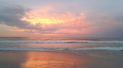 Obraz premium A serene beach scene at sunset with pastel pinks and oranges illuminating the clouds and sky